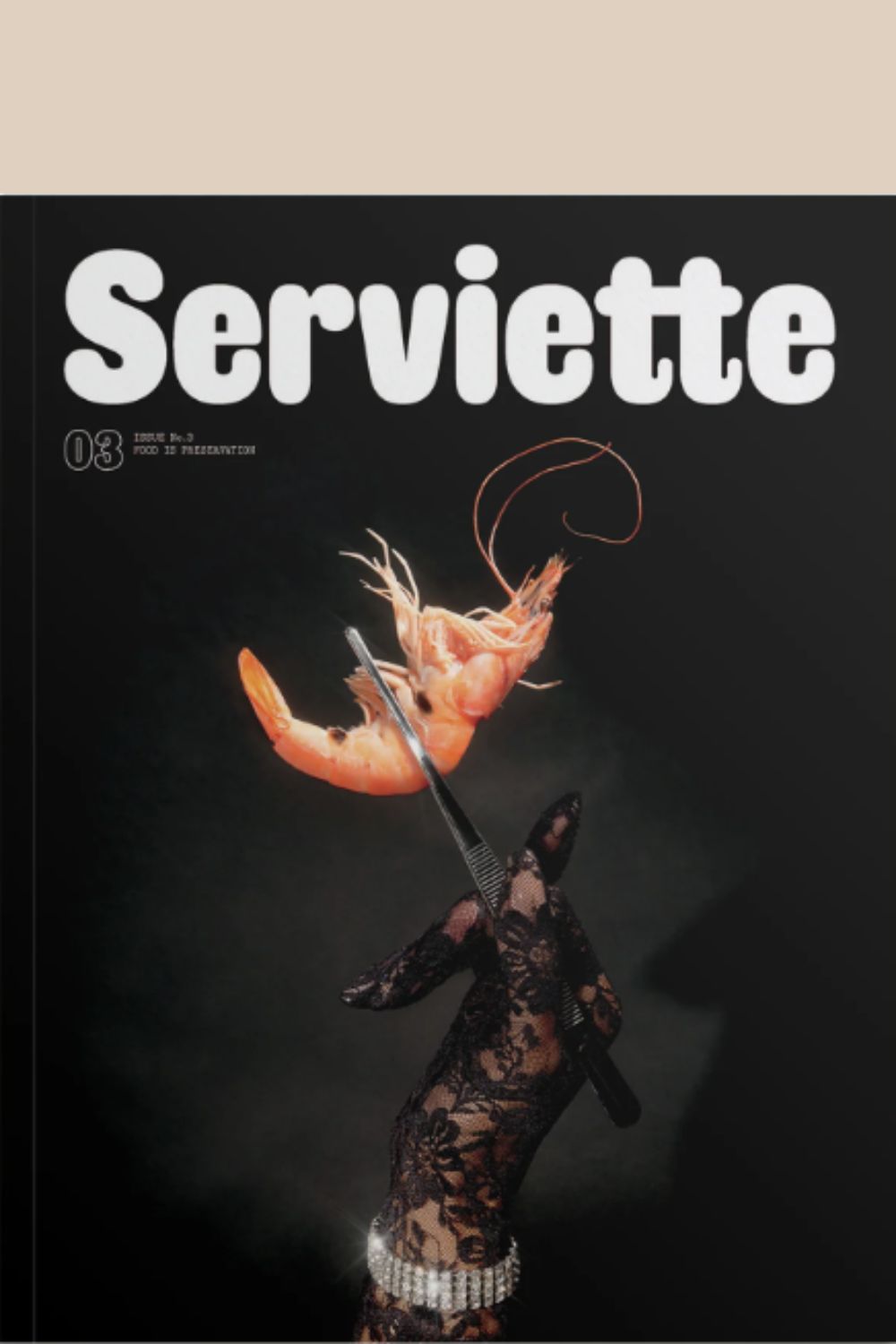 Serviette Magazine Issue 3 cover with a black laced glove hand holding a shrimp in a pair of tweezers