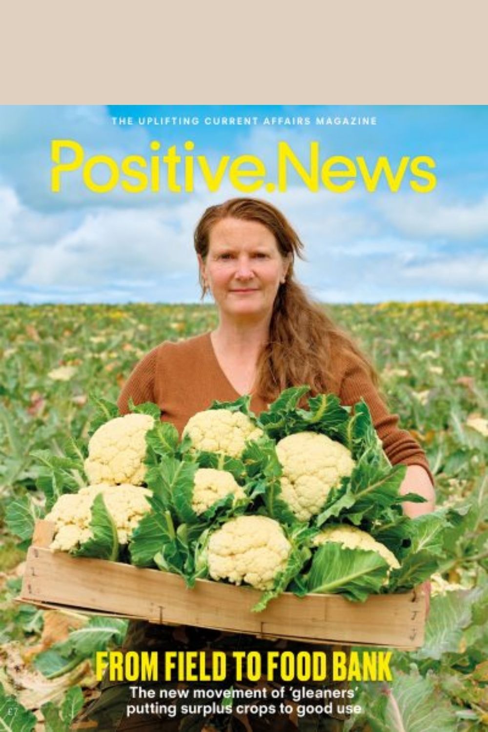 independent female farmer carrying cauliflowers on the cover of Positive News